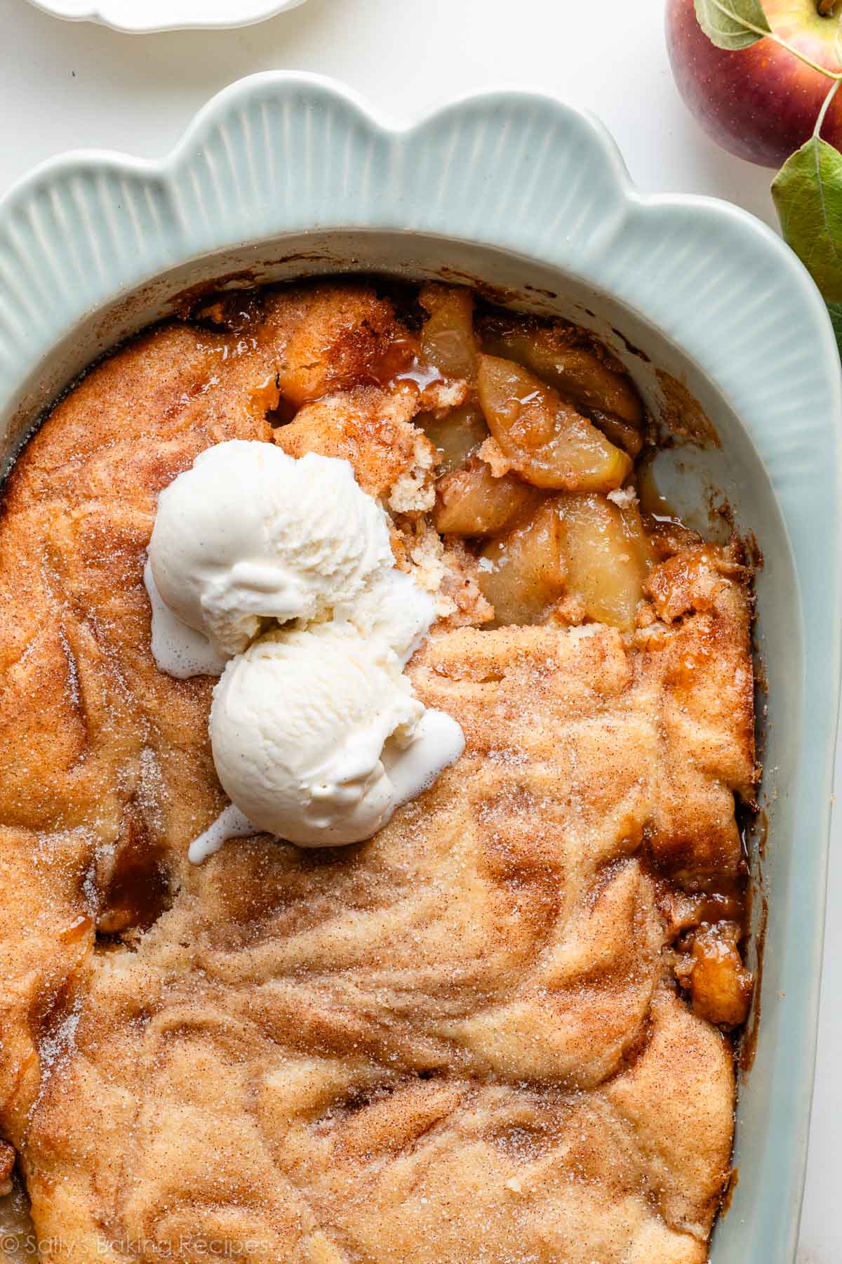 apple cobbler with cinnamon sugar and ice cream on top.